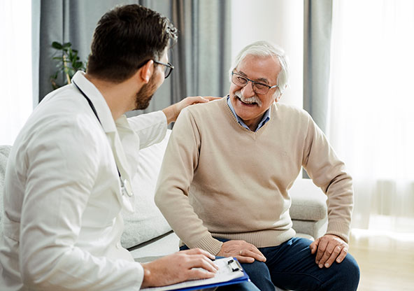 A senior man smiles with his oncologist