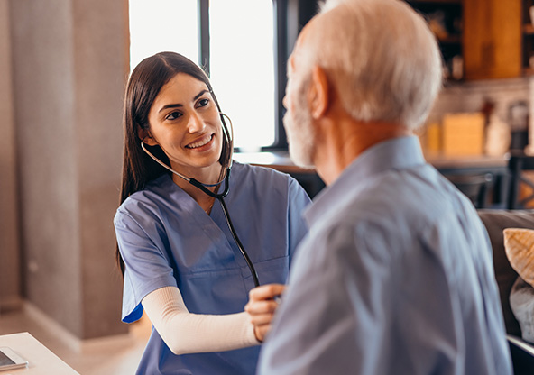 A nurse listens to a senior man's heart and lungs